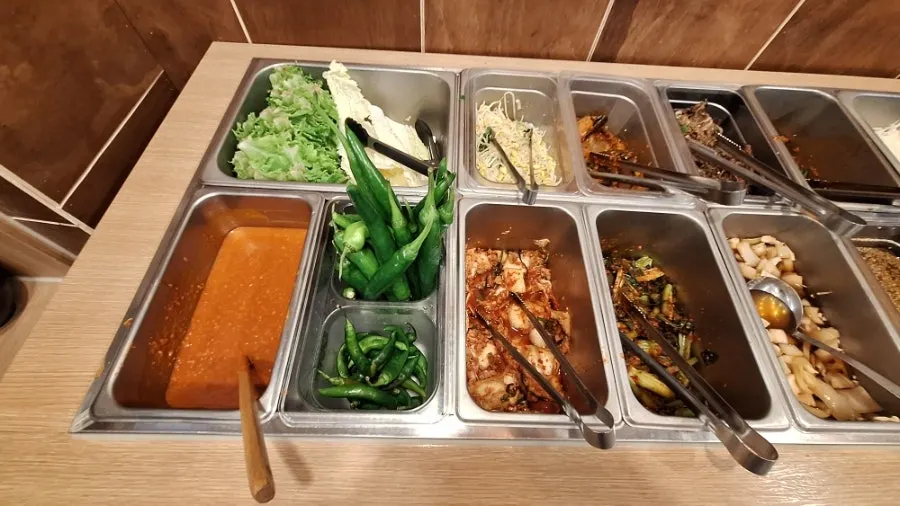 Cabbage water kimchi and kimchi laid out at Jeju Badang's self-serve bar