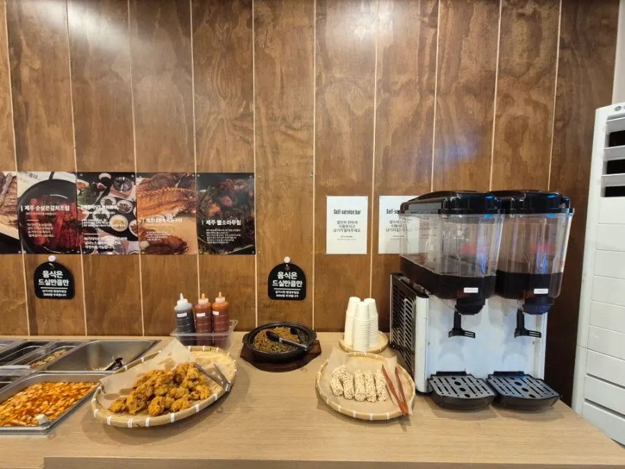 The kimchi and warm side dish corner of the self-serve bar