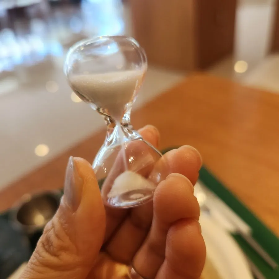 Teapot steeping tea alongside an hourglass