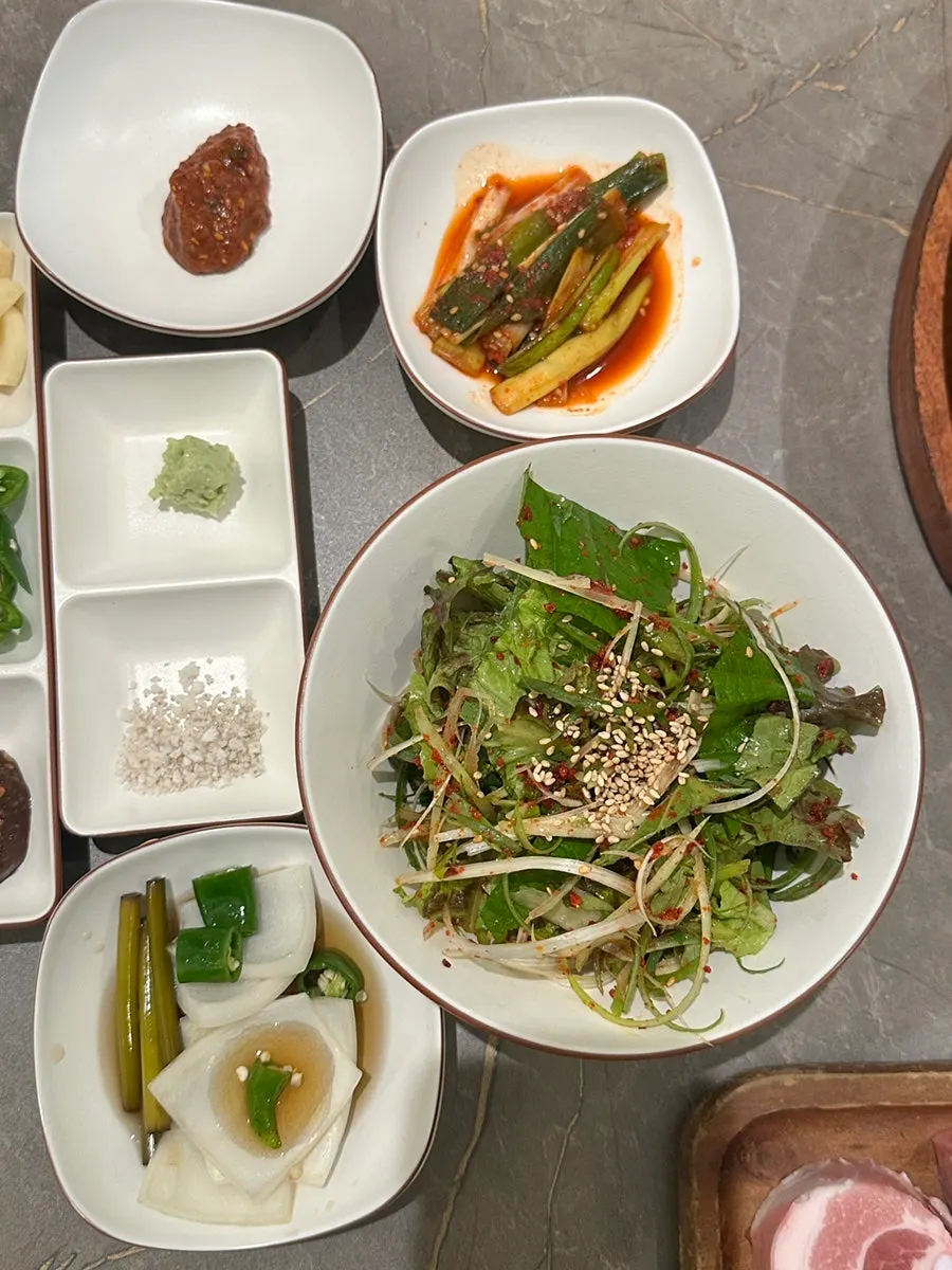 Banchan with pickled vegetables and pink sausage