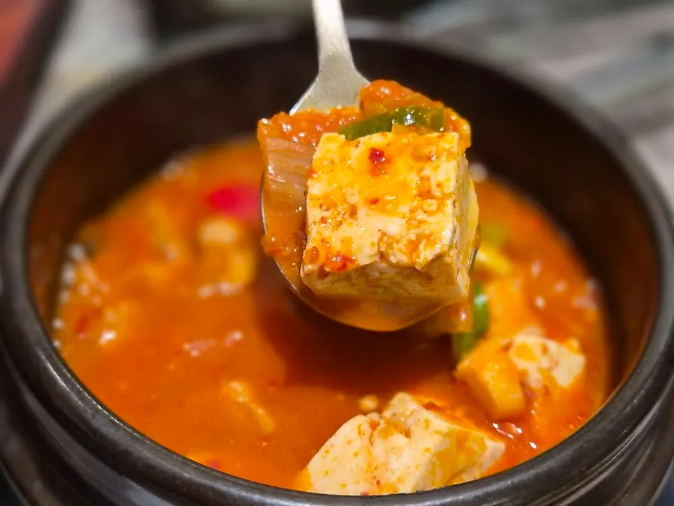 Spooning up the spicy kimchi jjigae