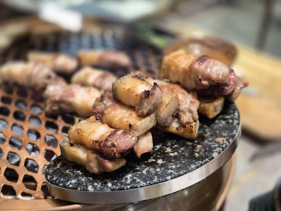 Cooked meat moved onto the shelf beside the grill