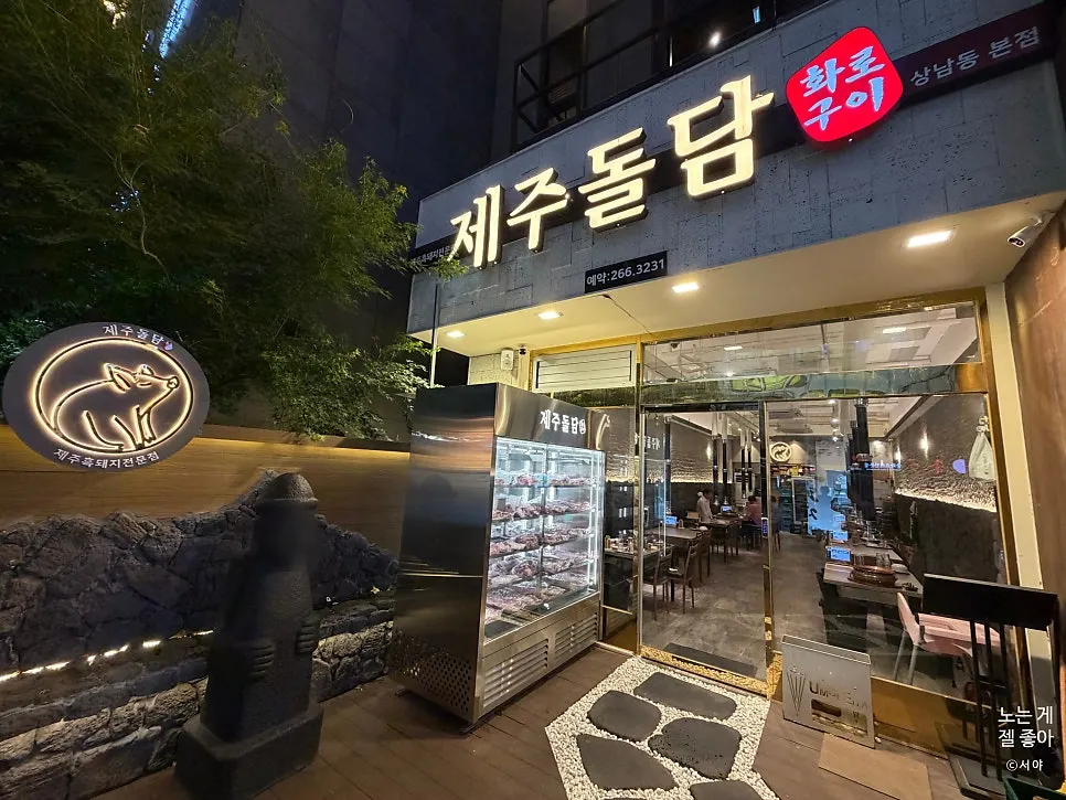 店门前摆放石头爷爷雕像的济州石墙入口