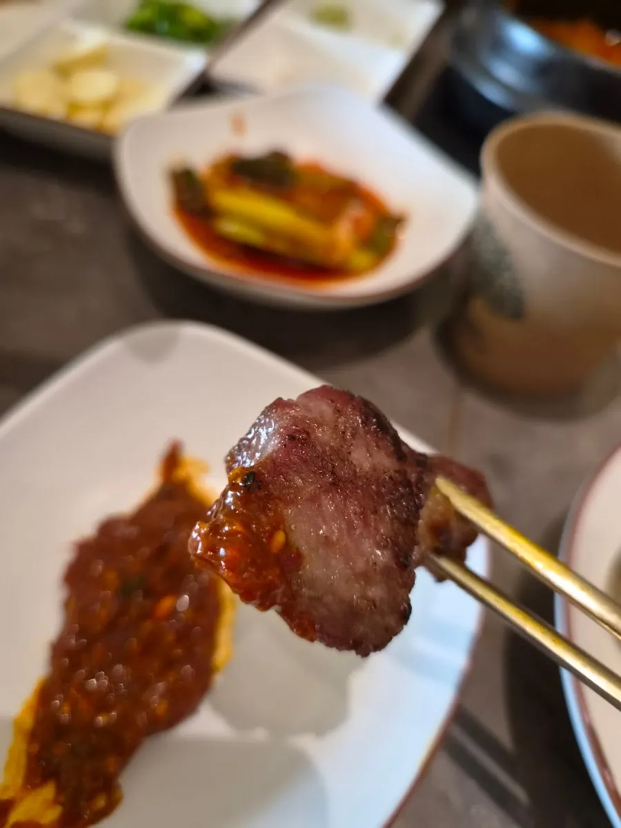 A piece of pork belly with kimchi and wasabi