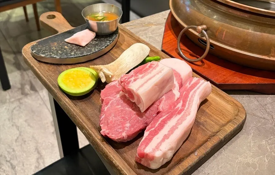접시에 담긴 생 흑돼지 오겹살과 목살