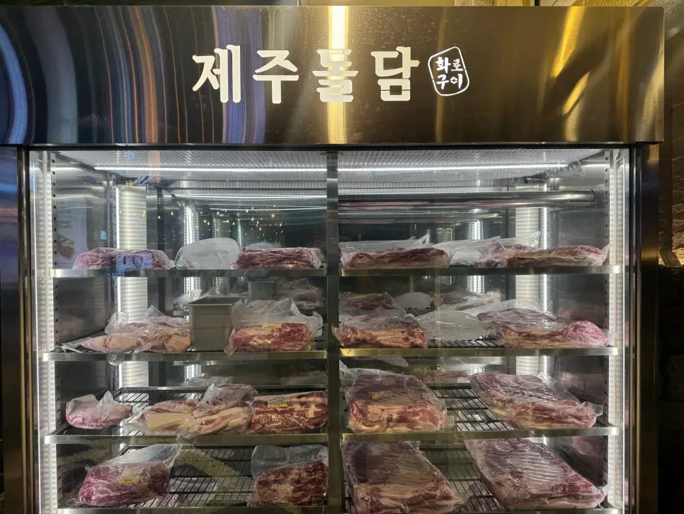 Raw black pork hanging inside the aging chamber