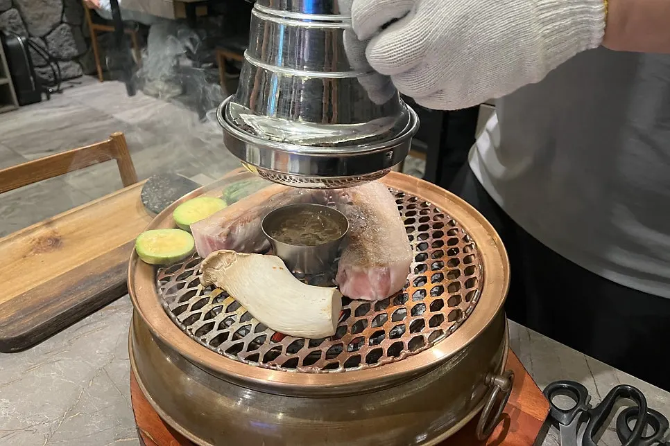 Black pork oegyeopsal placed on the grill