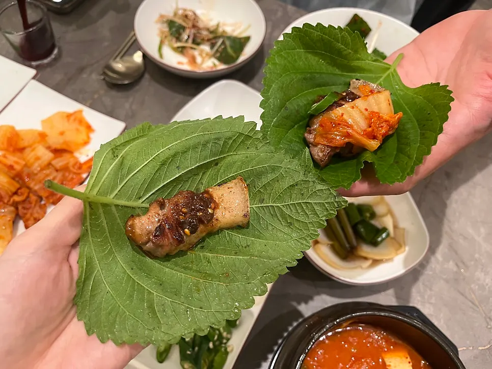 A lettuce wrap topped with meat and kimchi