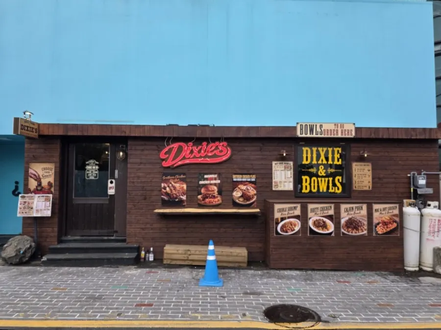 Dixie's wood-toned exterior on the first floor of a blue building