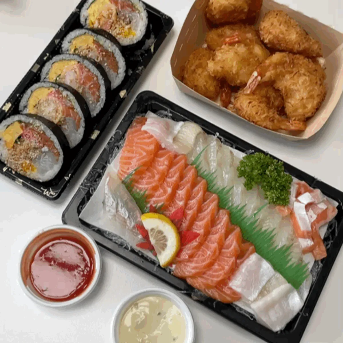 Sashimi, futomaki and fried shrimp laid out together