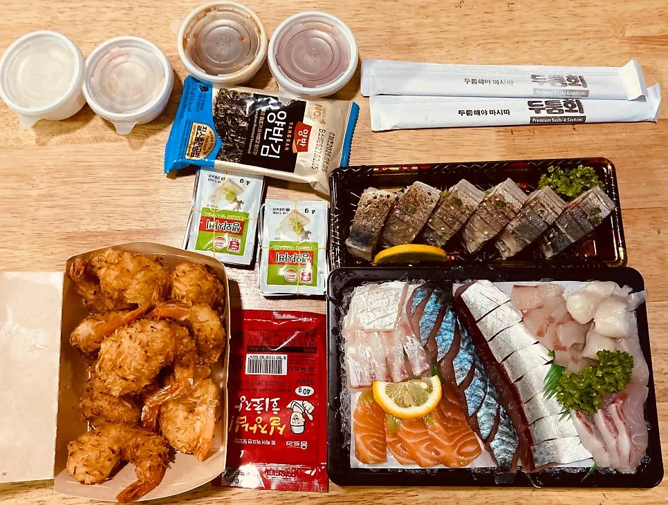 Sashimi, sushi, and fried shrimp arranged together at the stay