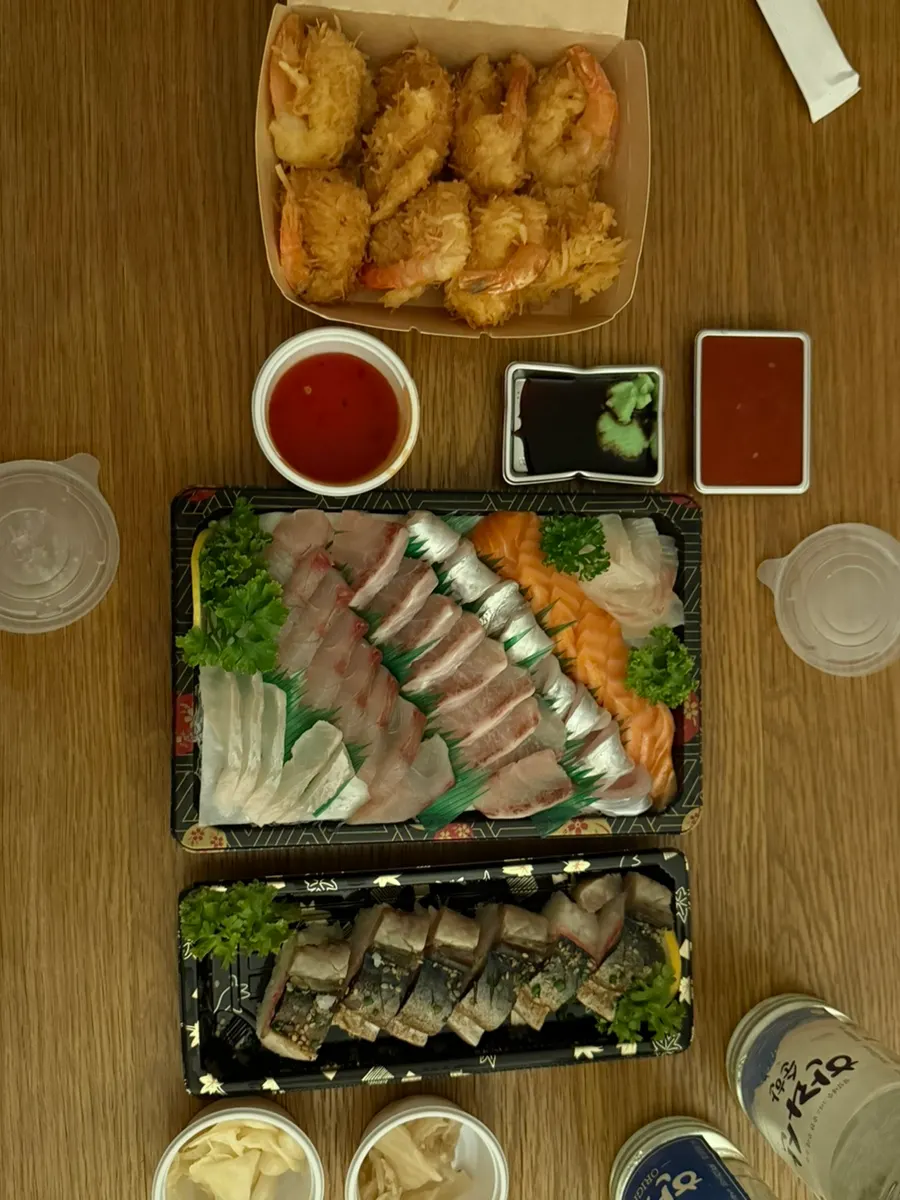Mâm cơm tối tại homestay gồm sashimi thập cẩm, sushi và đồ ăn kèm