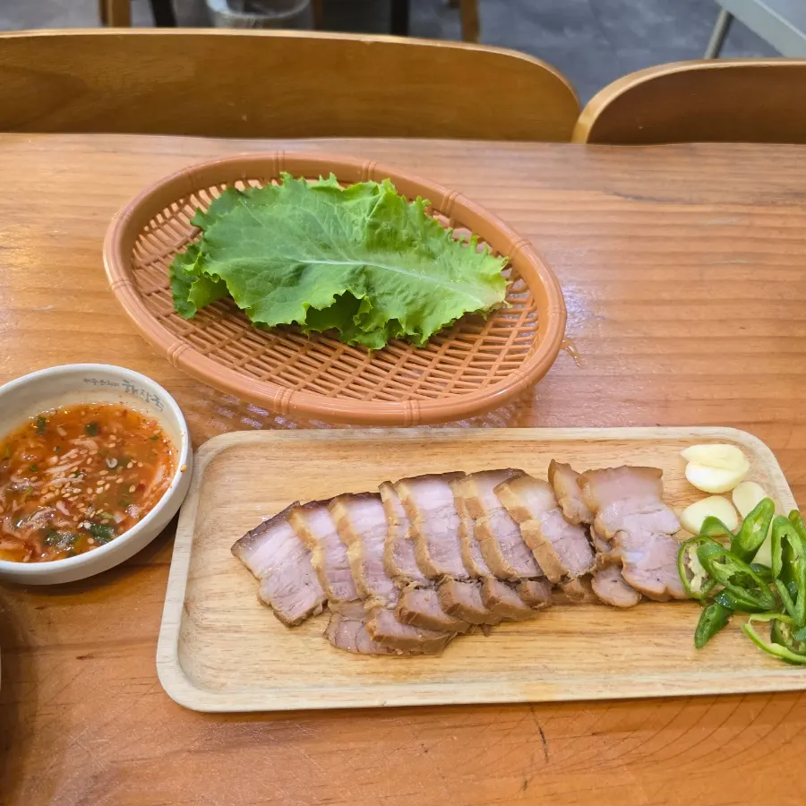 새우젓과 쌈채소가 곁들여진 돔베고기 한 접시