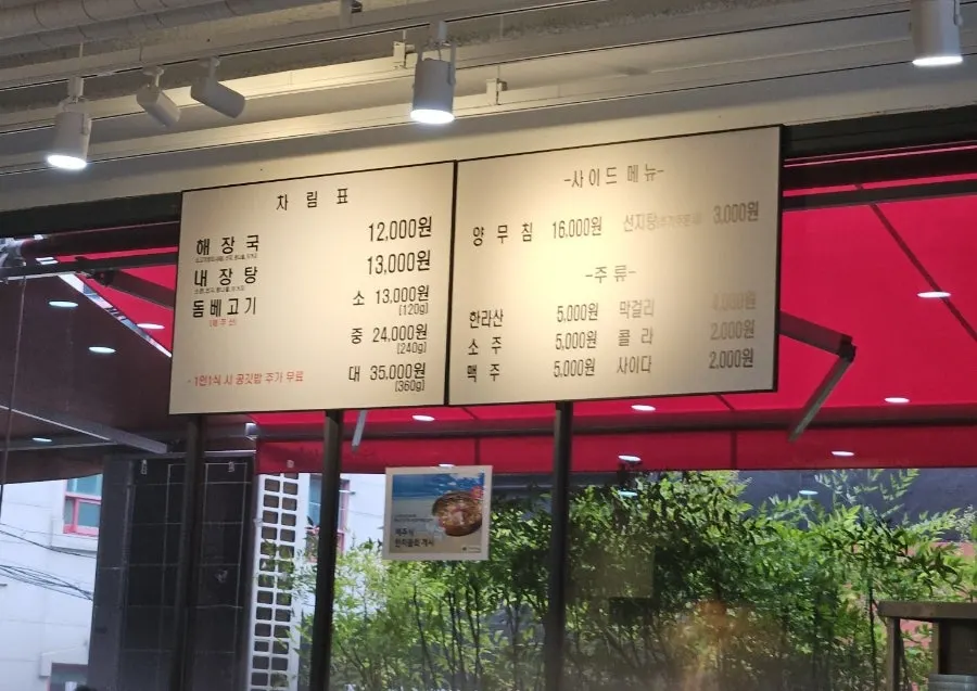 Menu board listing haejangguk, tripe soup, and dombe pork