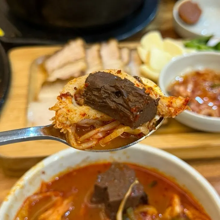 숟가락으로 떠 올린 내장탕 국물과 양