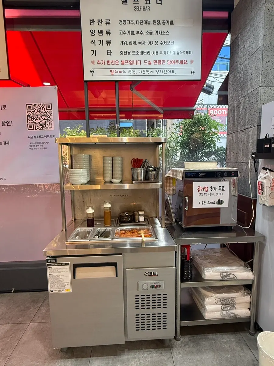 Self-serve bar with side dishes, chili oil, and pepper