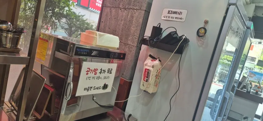 Sign announcing free rice refill with a one-person-one-dish order
