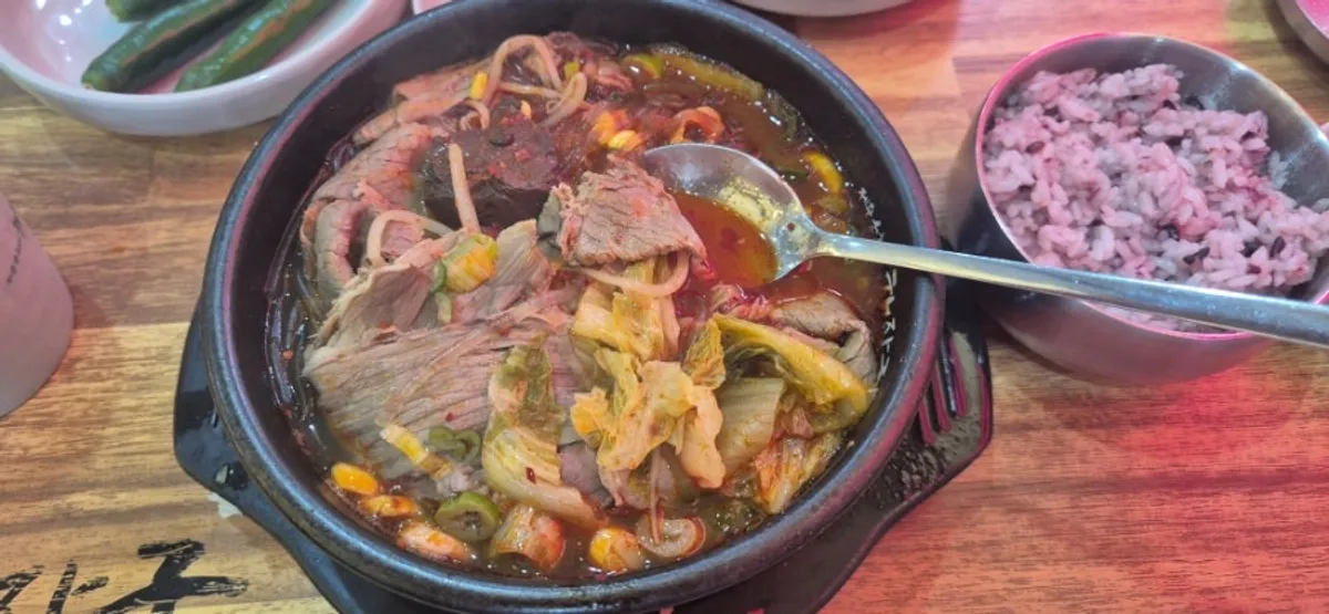 A spoonful of haejangguk with meat and glass noodles