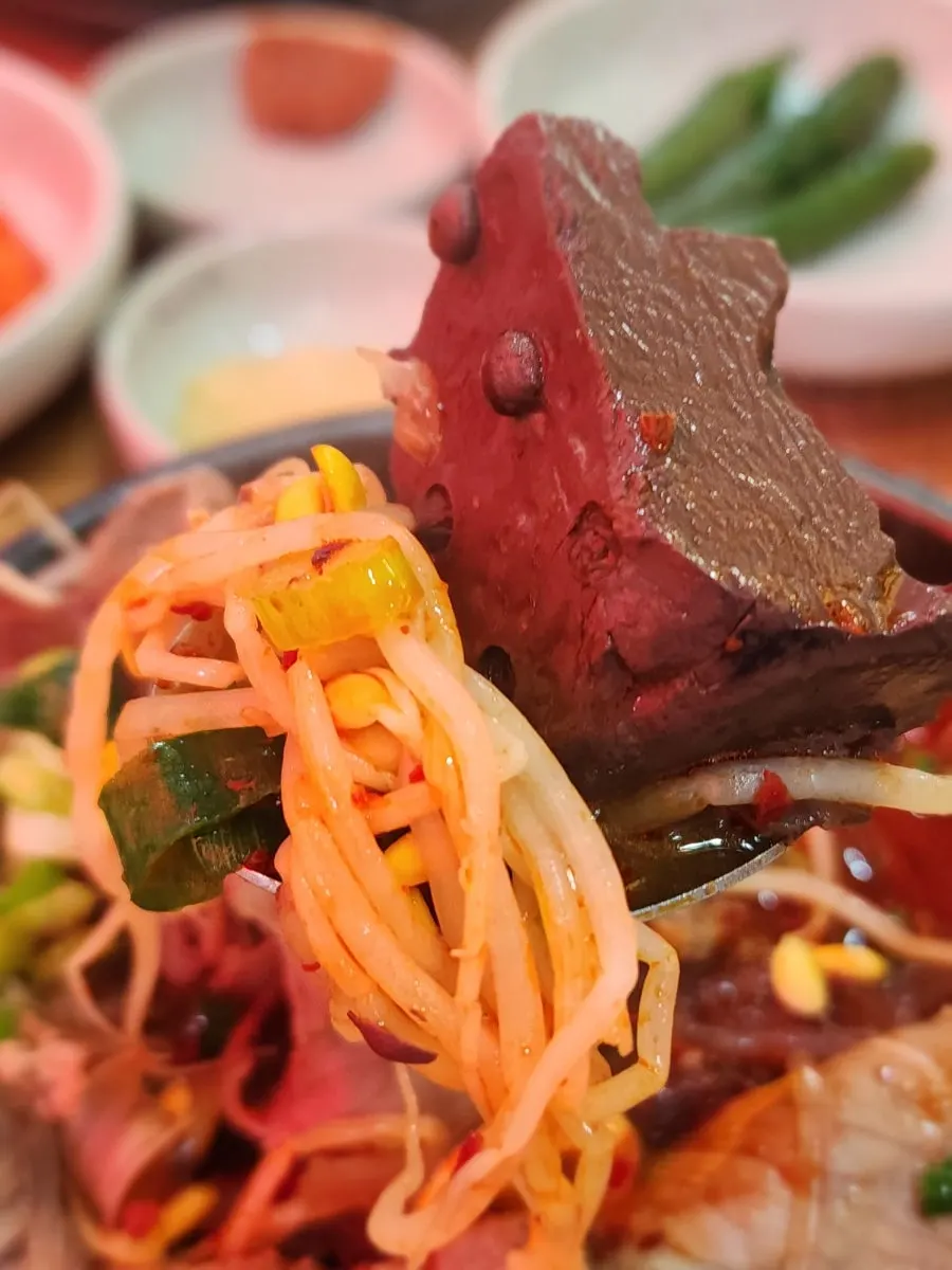 A spoonful of bean sprouts and meat from the haejangguk