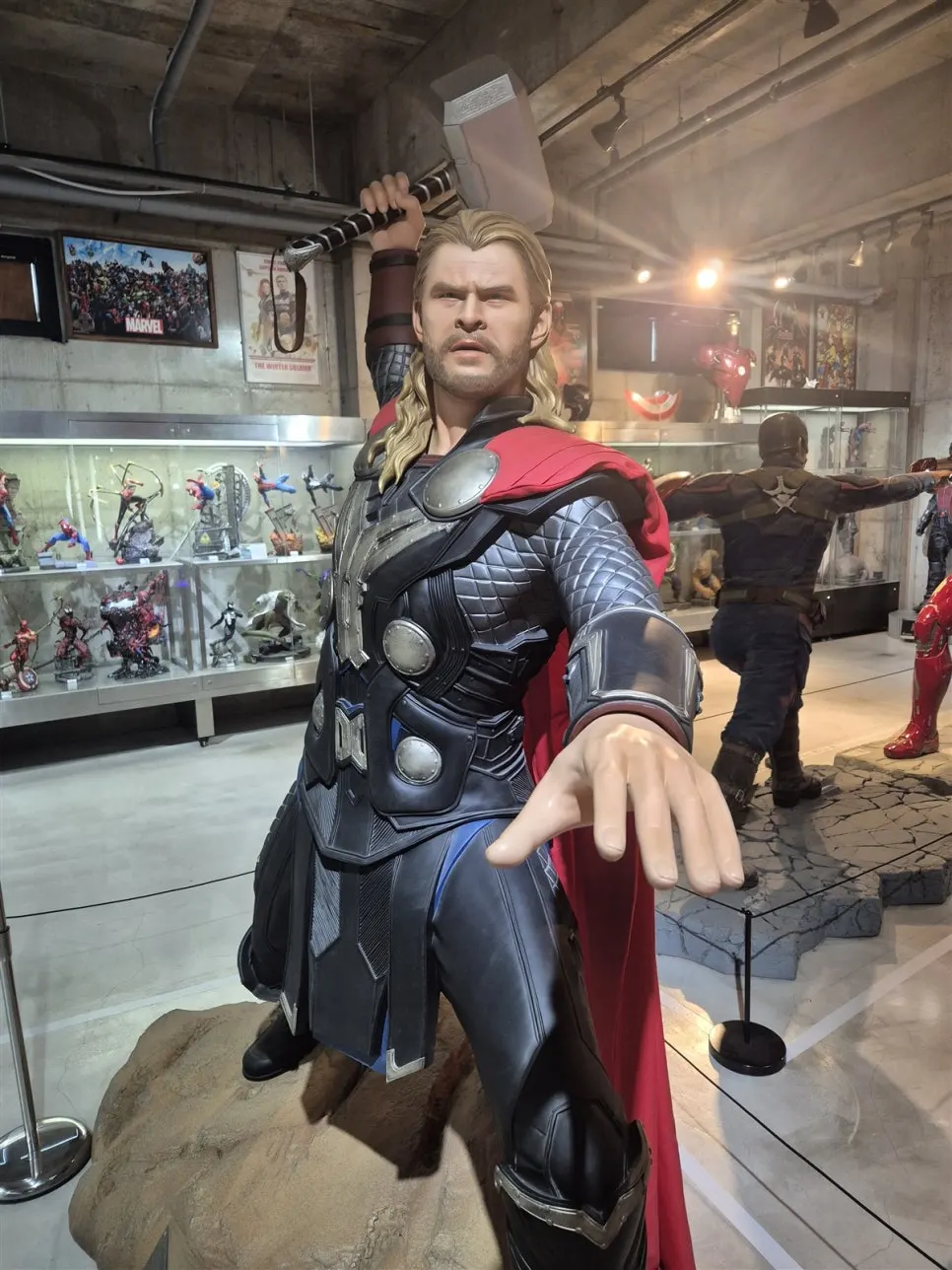 Thor reaching out his hand and a Doctor Strange statue