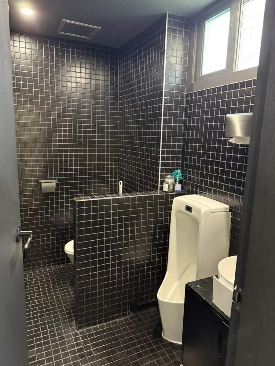 The mirrored door leading to the restroom