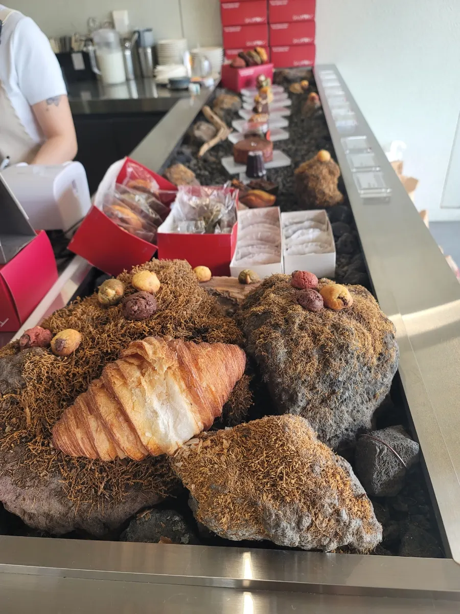 Dessert display by the counter styled with basalt stone and moss