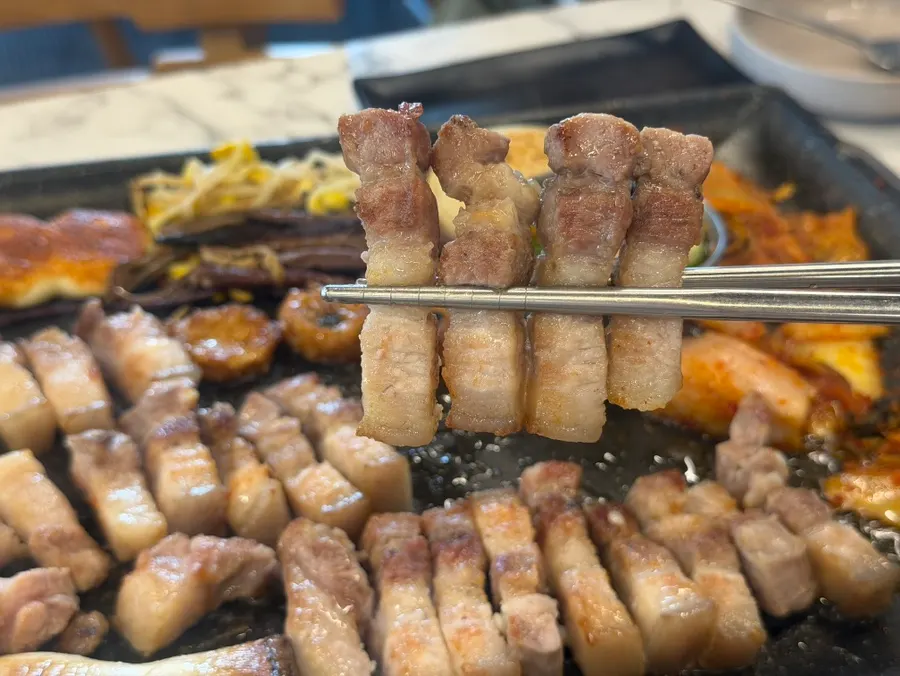 A grilled piece of black pork ready to dip in salt