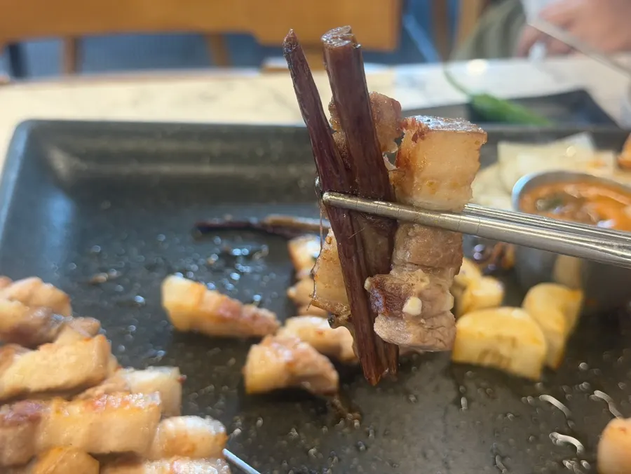 Fern and aged kimchi grilling on the plate