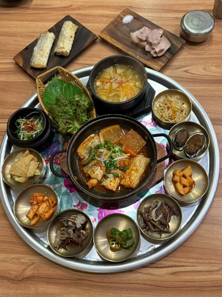 13-dish table setting with grilled cutlassfish and dombe gogi
