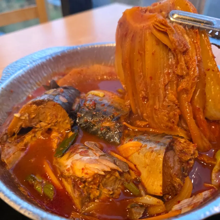 Pot of mackerel ssambap topped with aged kimchi