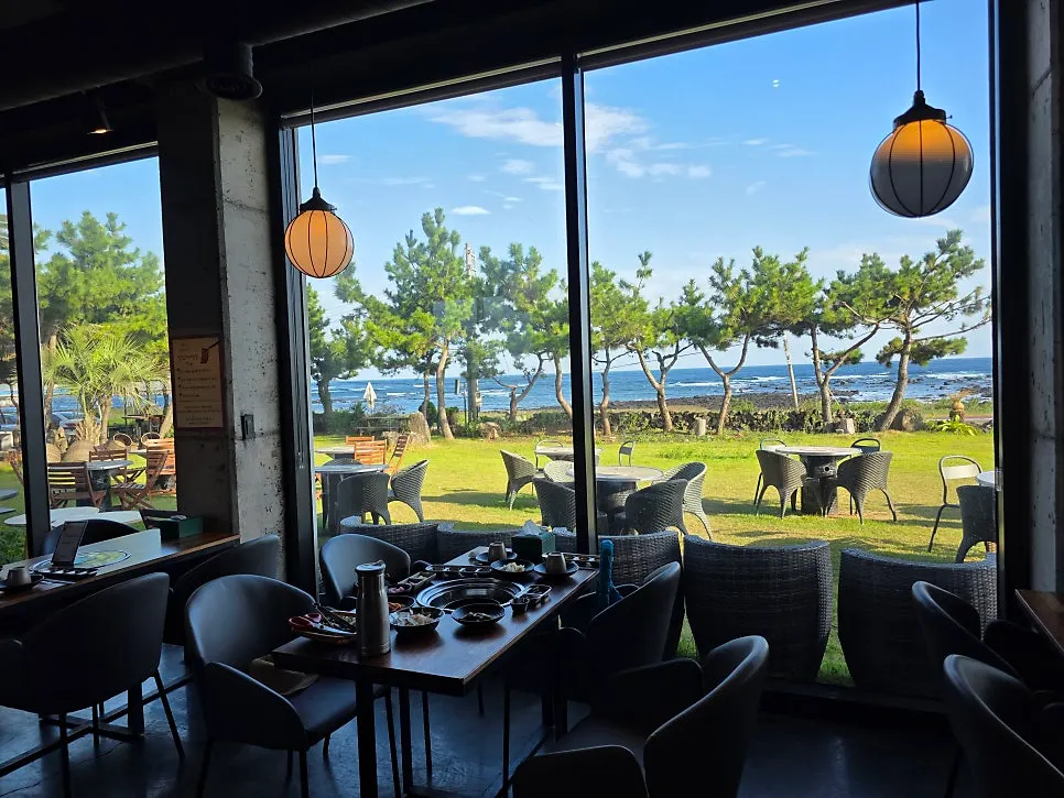 Indoor seating with picture windows at Jeju Healing Dwaeji