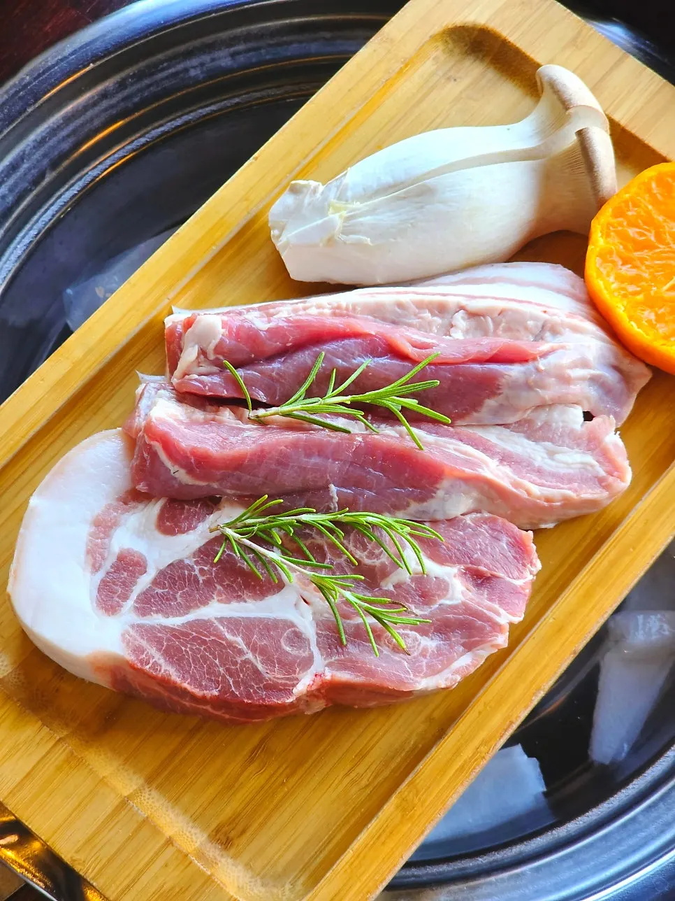 Thick raw black pork topped with tangerines