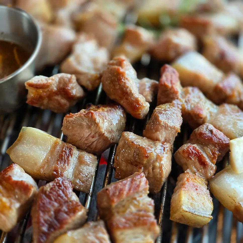 Pre-seared black pork cooking over charcoal