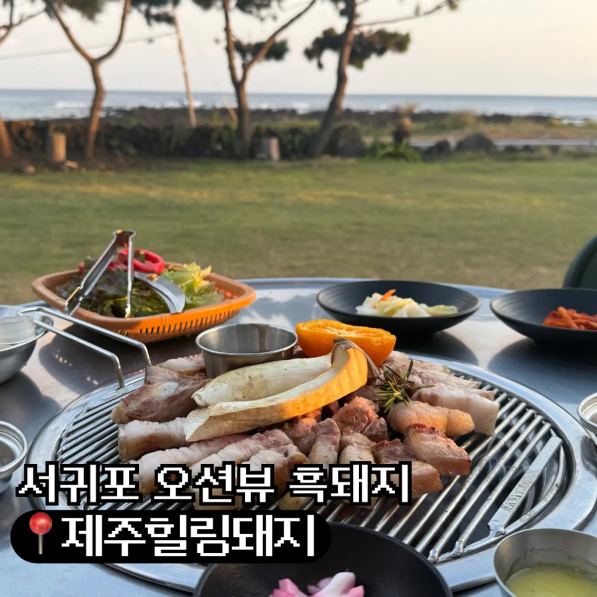 Ocean-view outdoor seating and black pork spread at Jeju Healing Dwaeji