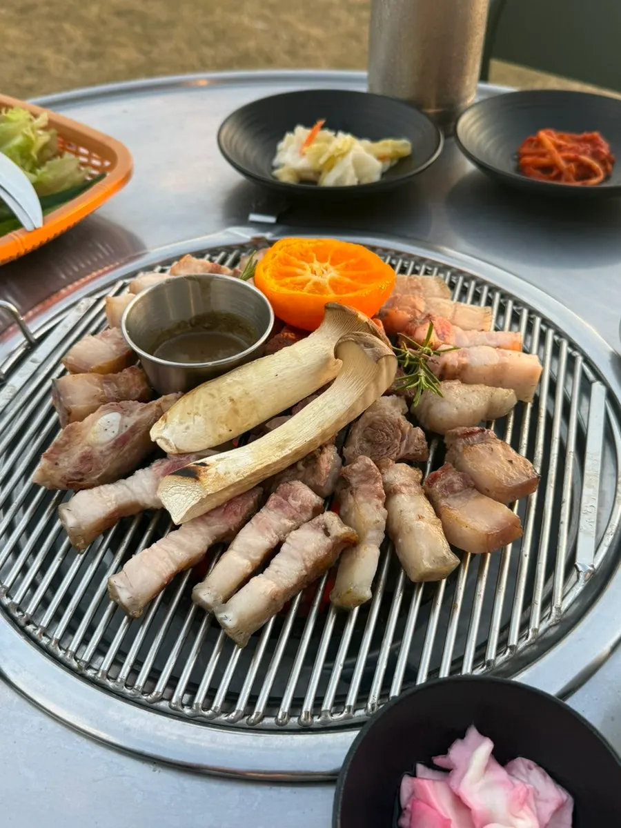 Raw black pork geun served with mushroom and tangerine
