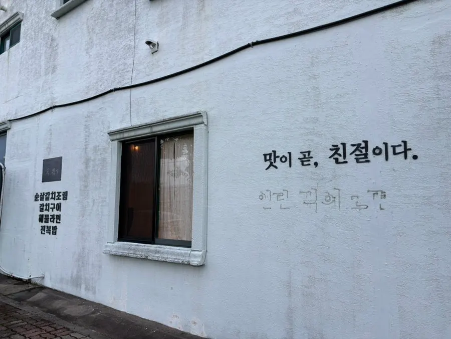 맛이 곧 친절이다 문구가 있는 식당 외관
