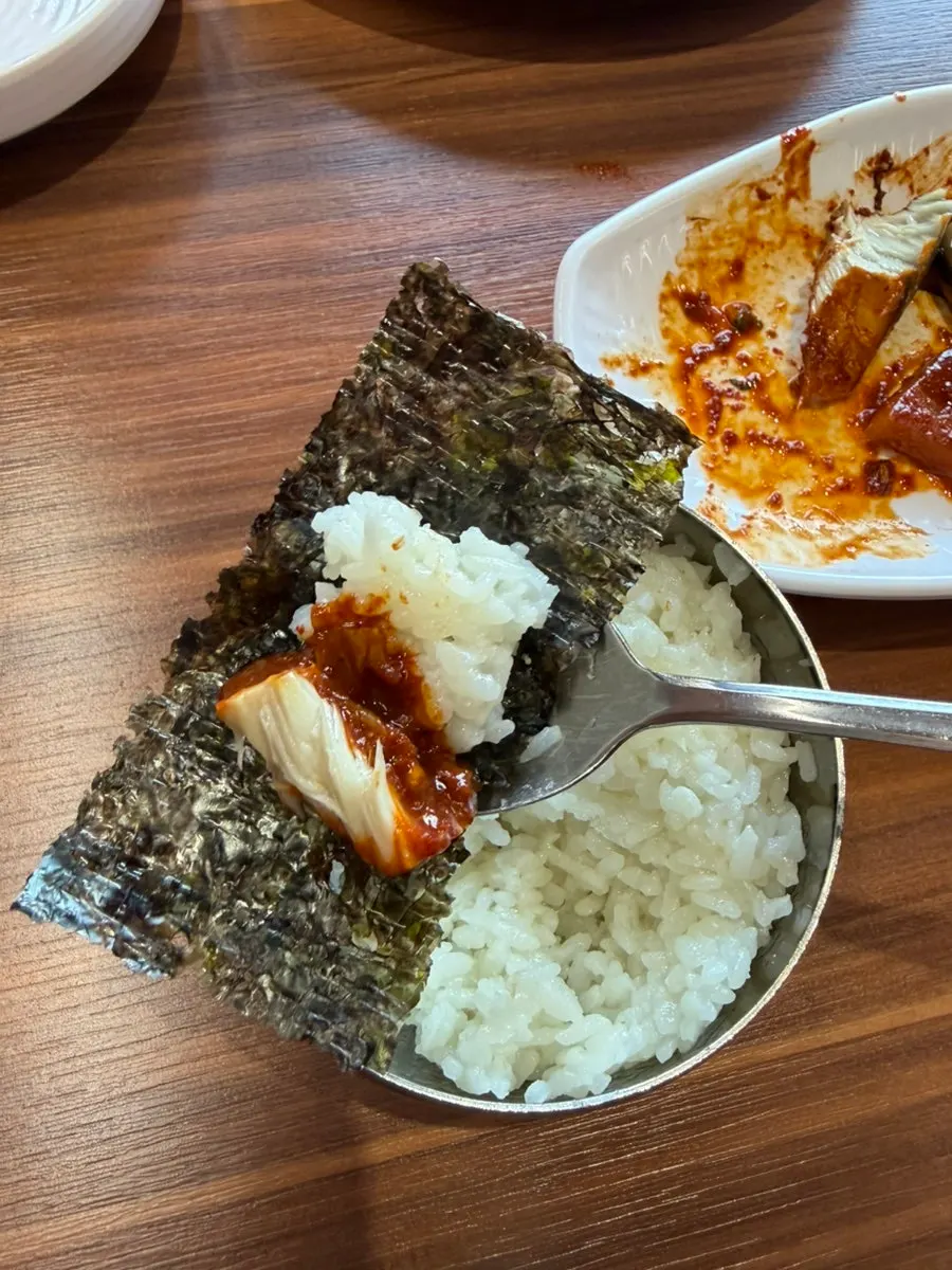 A bite of stew paired with seaweed