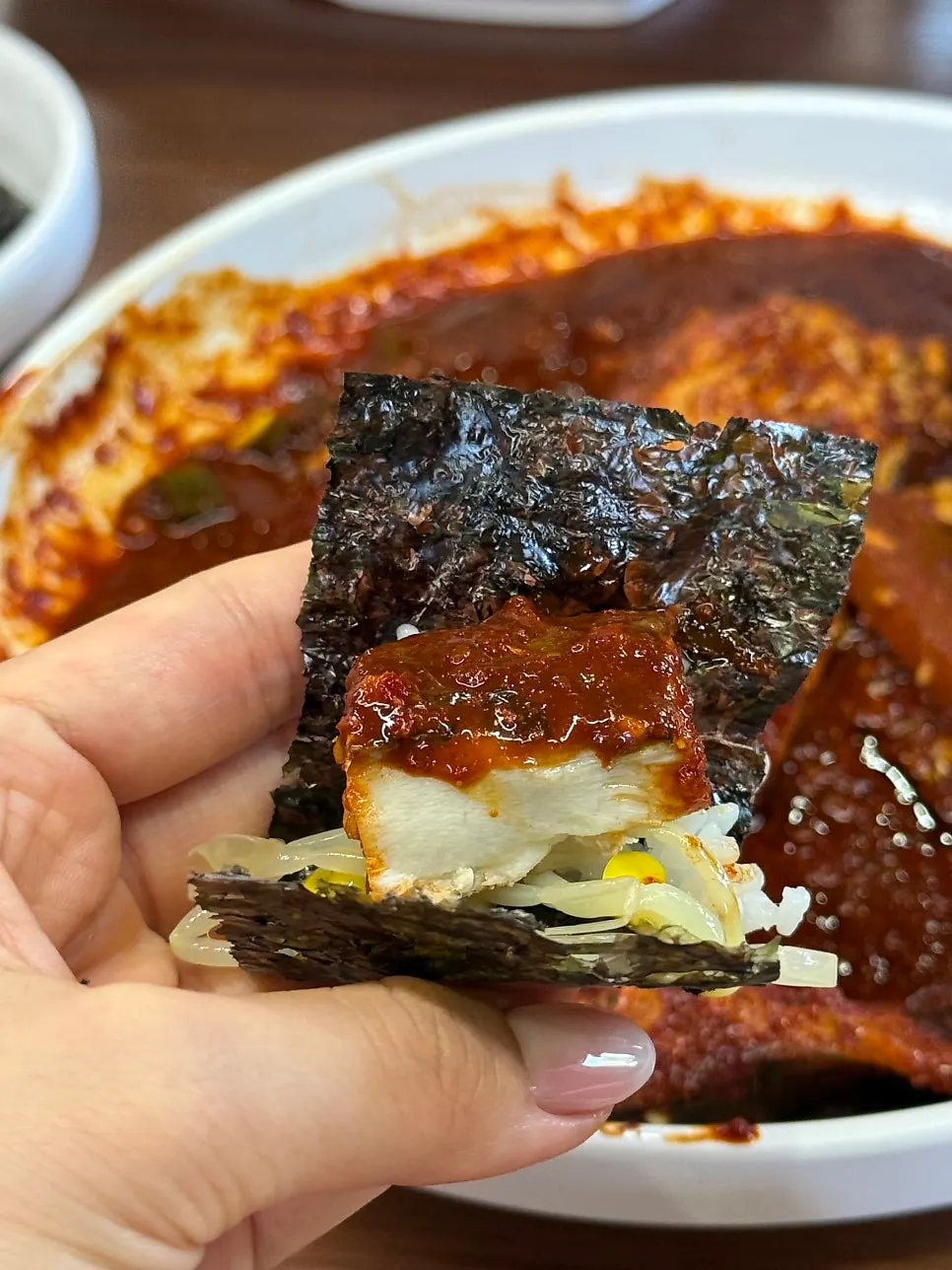 A bite of hairtail stew wrapped in laver