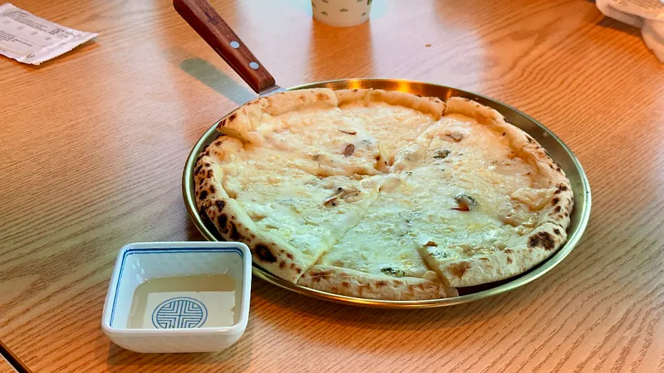 A cheesy slice of the wood-fired pizza