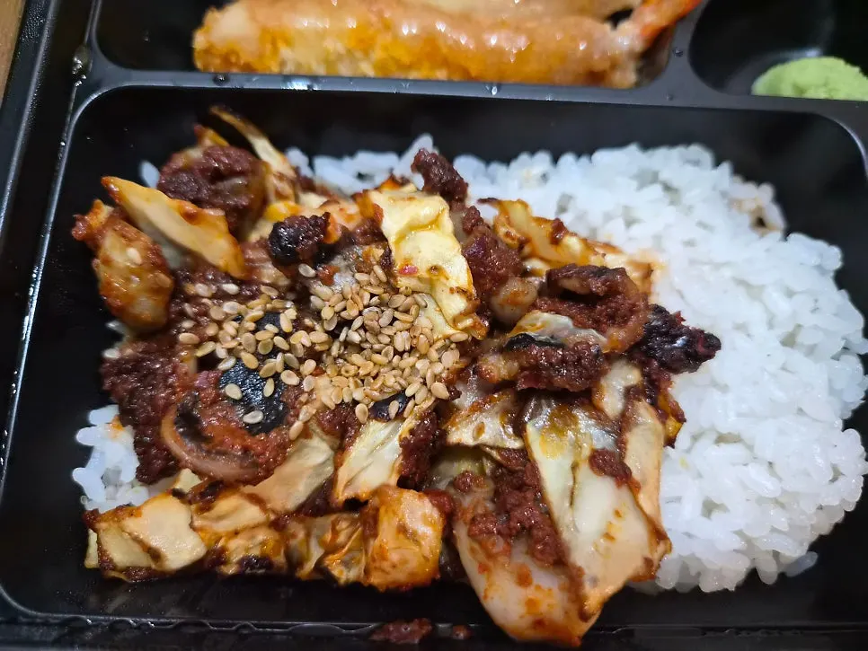 Inside of the lunch box with sushi and fried items