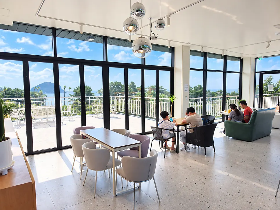 View through the floor-to-ceiling windows at the Seogwipo ocean-view café