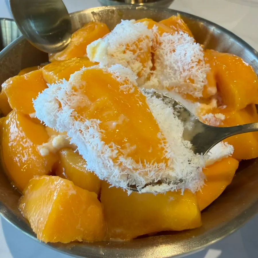 Pouring mango purée over milk ice