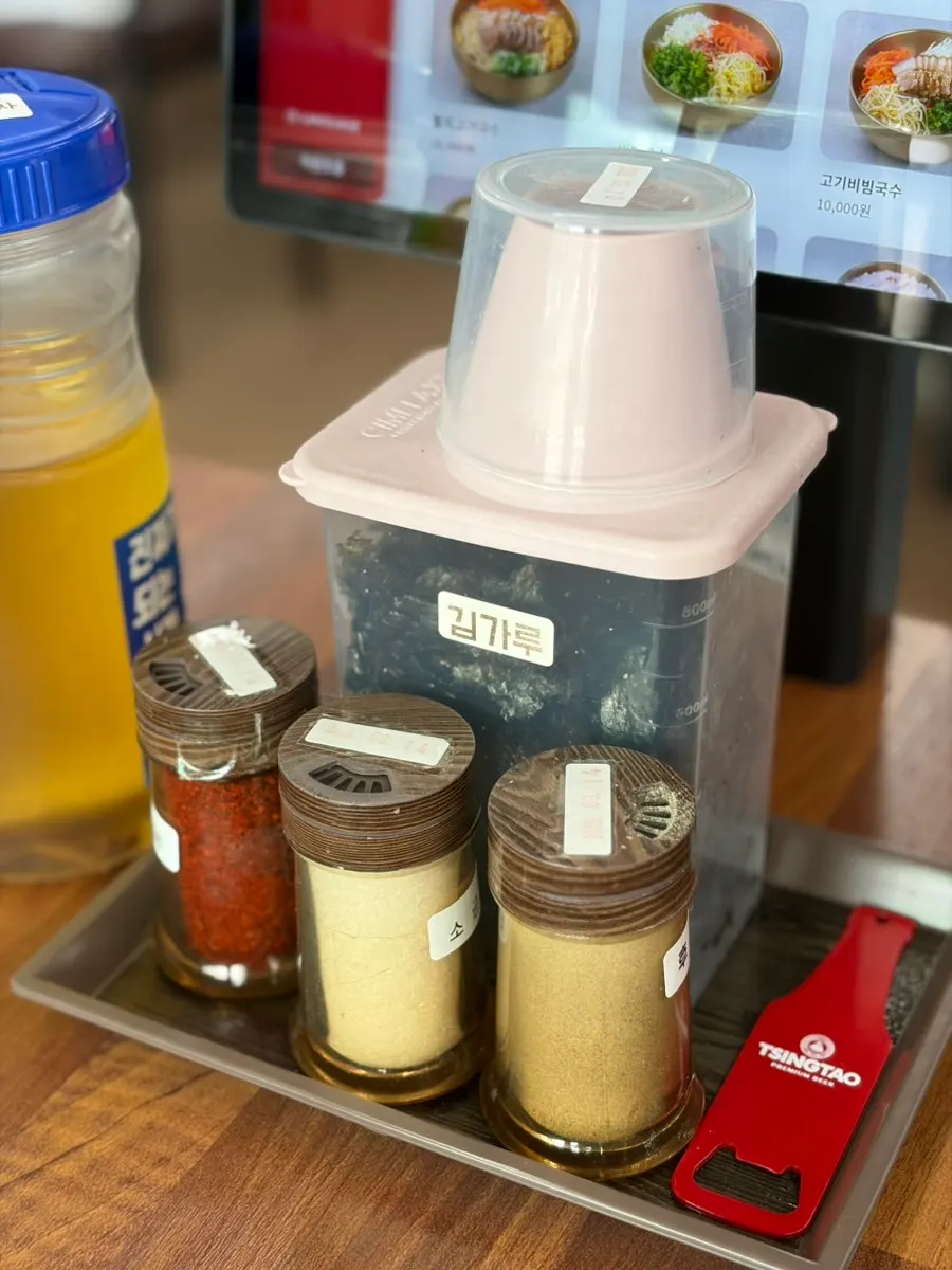 Dated seaweed flakes, salt, and pepper bottles on the table