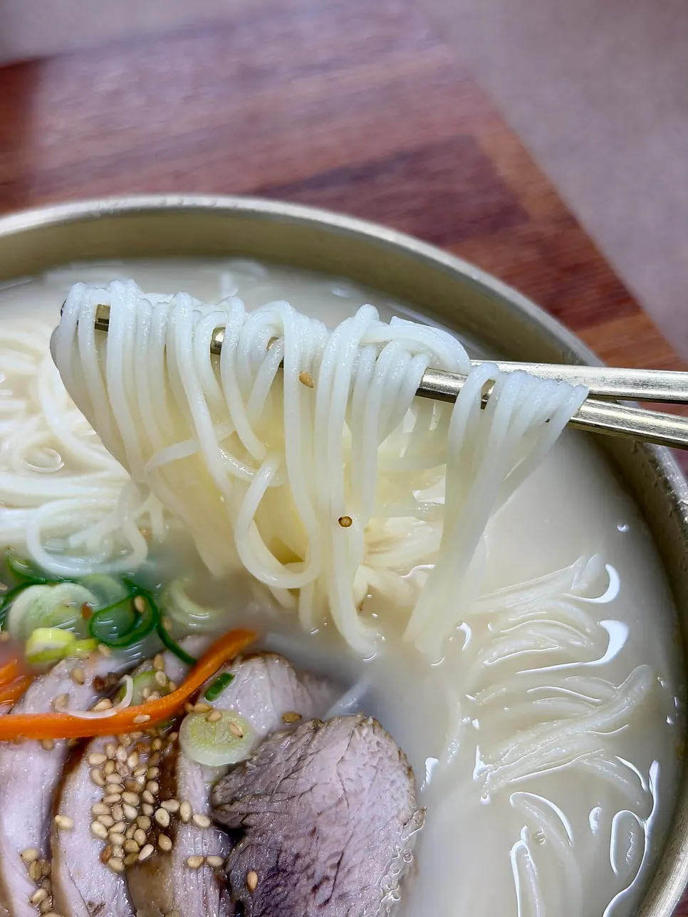 Chewy noodles lifted up with chopsticks