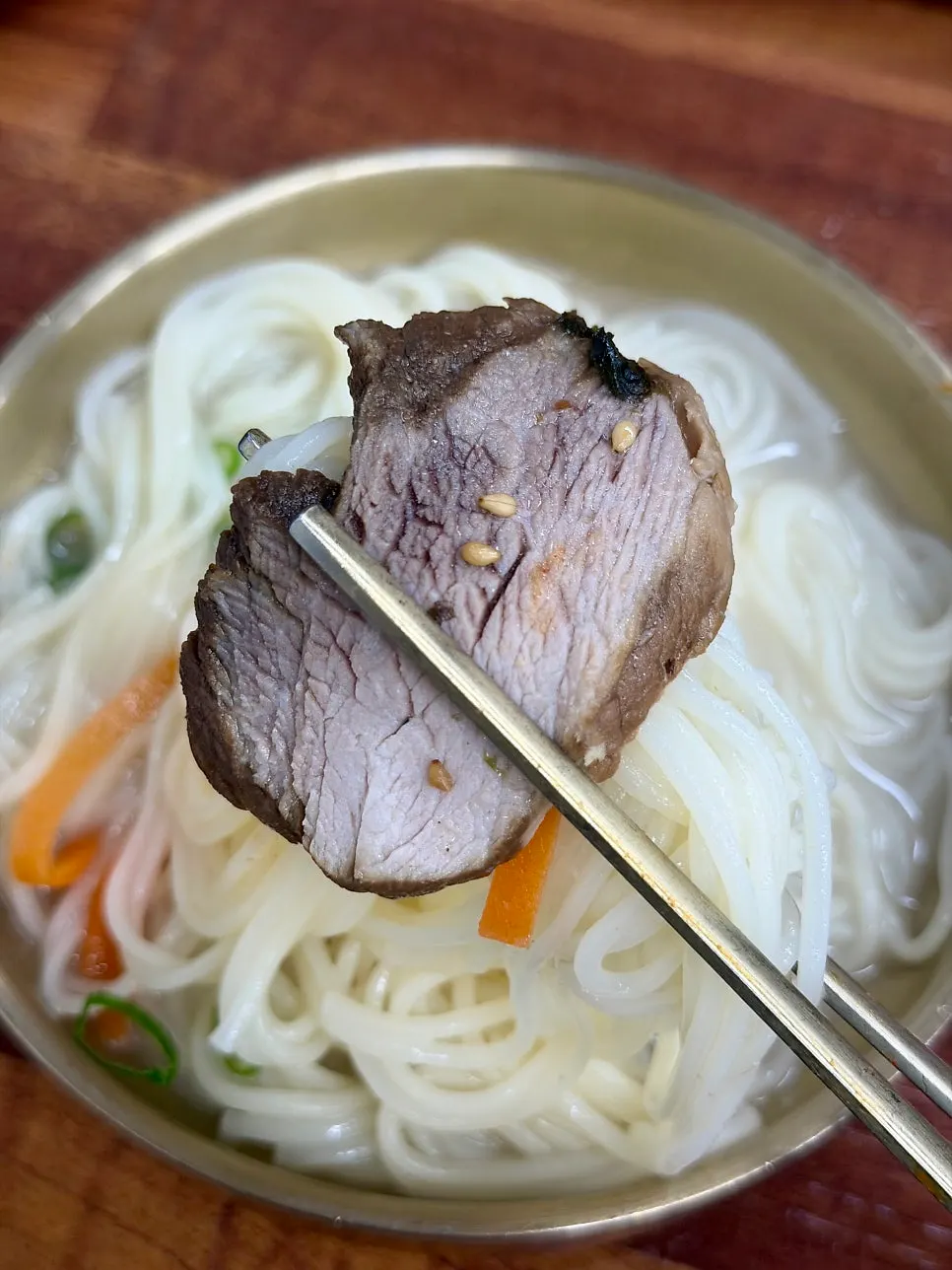 A bite of noodles and black pork together with broth