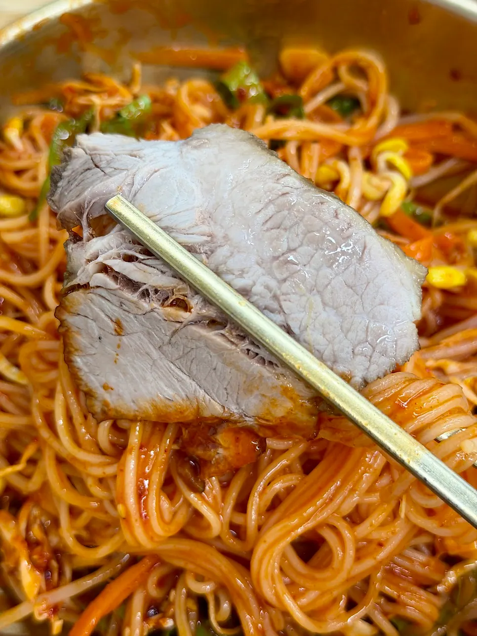 Bibim guksu piled high with black pork topping