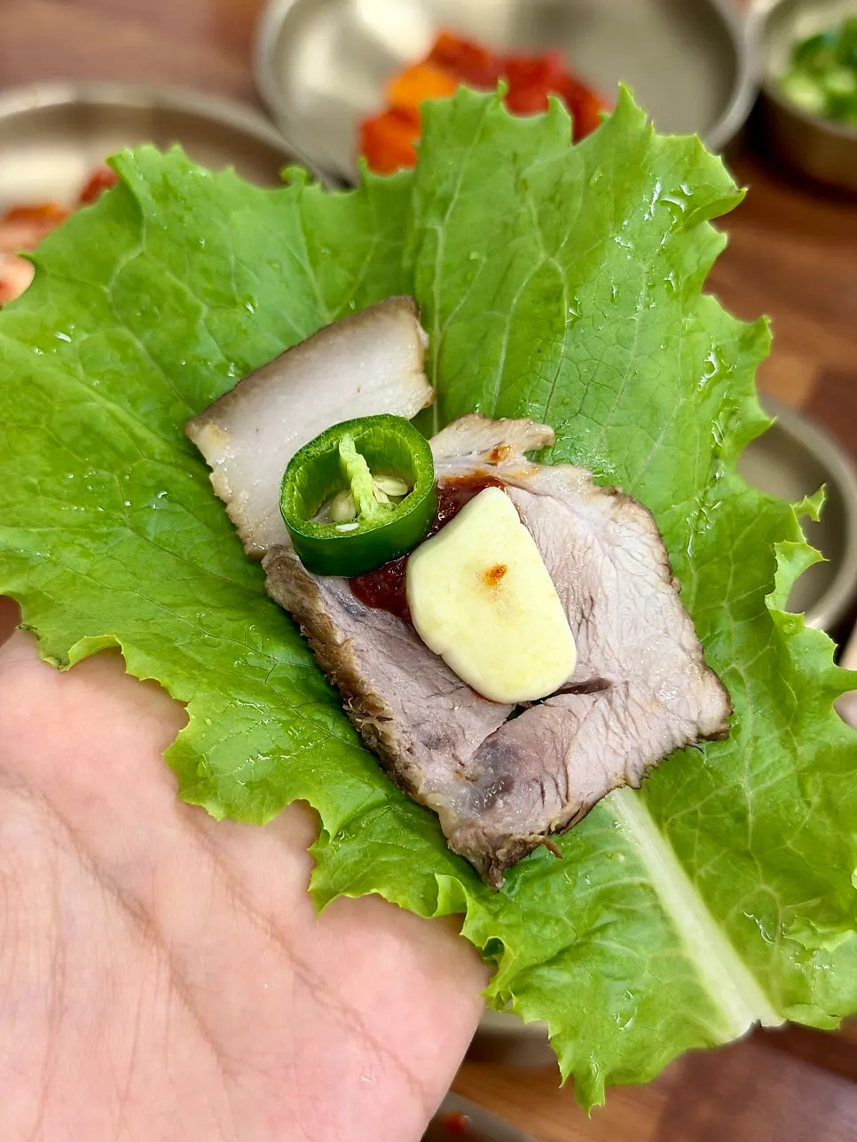 A bite of dombe pork wrapped in lettuce