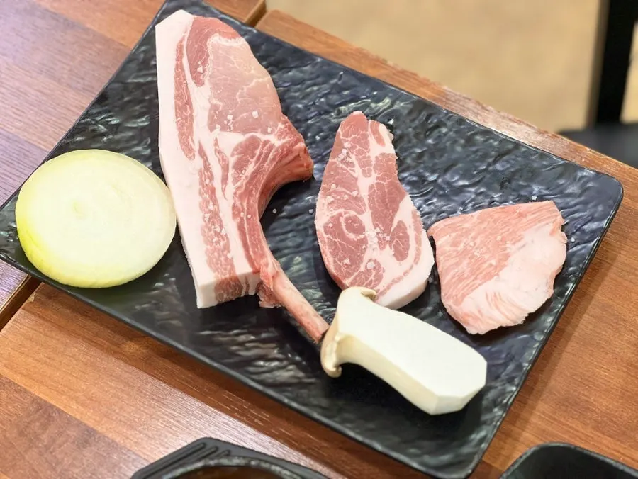 The dry-aged black pork half portion arriving at the table