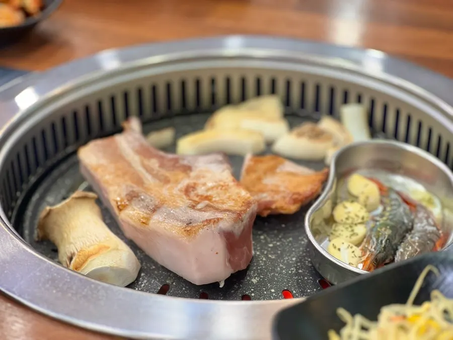 Staff grilling the thick black pork cuts