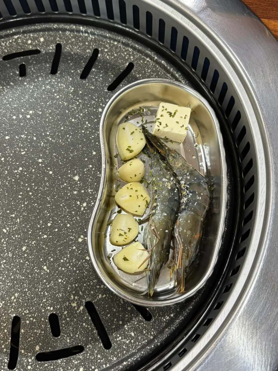 Prawns and garlic cooking in butter on the grill
